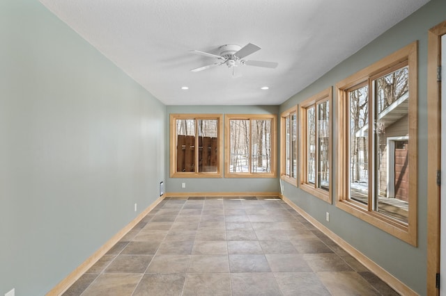 unfurnished sunroom featuring a ceiling fan