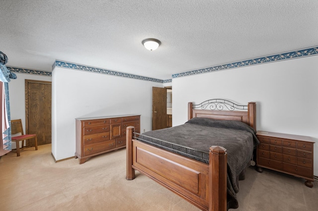 bedroom with light colored carpet and a textured ceiling