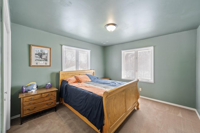 bedroom with light colored carpet and baseboards