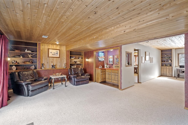 sitting room featuring built in features, wooden ceiling, carpet flooring, and wood walls