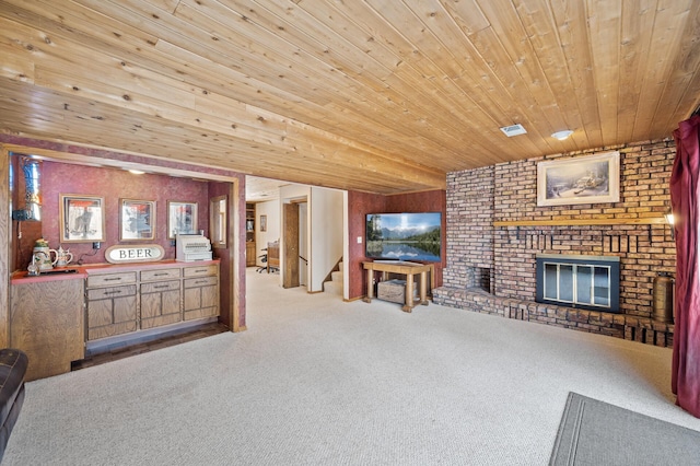 living room with visible vents, stairway, carpet floors, wooden ceiling, and a brick fireplace