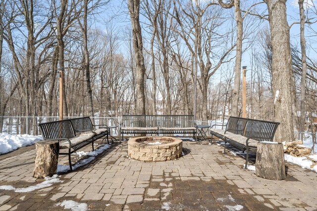 snow covered patio with a fire pit