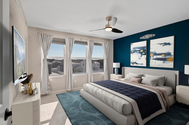 carpeted bedroom featuring baseboards and ceiling fan