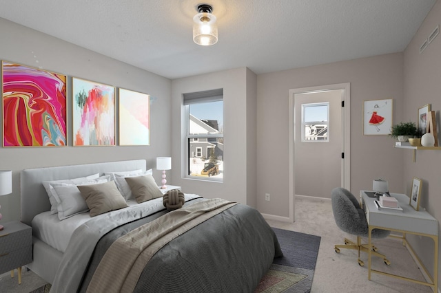 carpeted bedroom featuring visible vents, baseboards, and a textured ceiling