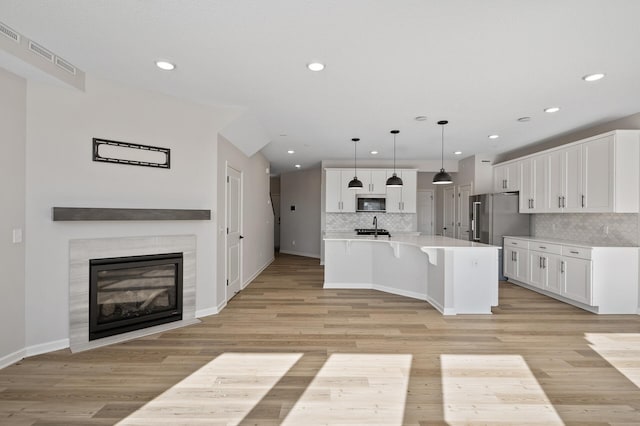 kitchen featuring light countertops, light wood-style flooring, white cabinets, and stainless steel appliances