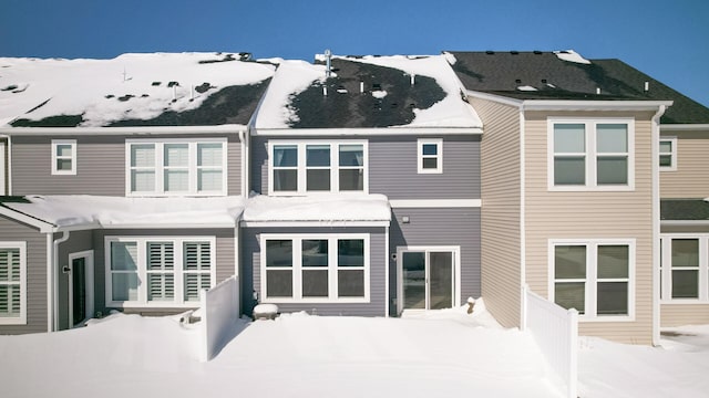 snow covered property with fence