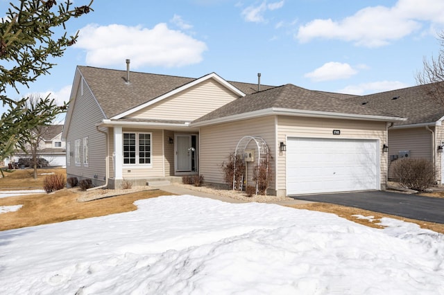 single story home with driveway, a shingled roof, and a garage