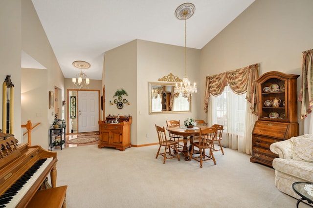 dining space featuring an inviting chandelier, light colored carpet, baseboards, and high vaulted ceiling