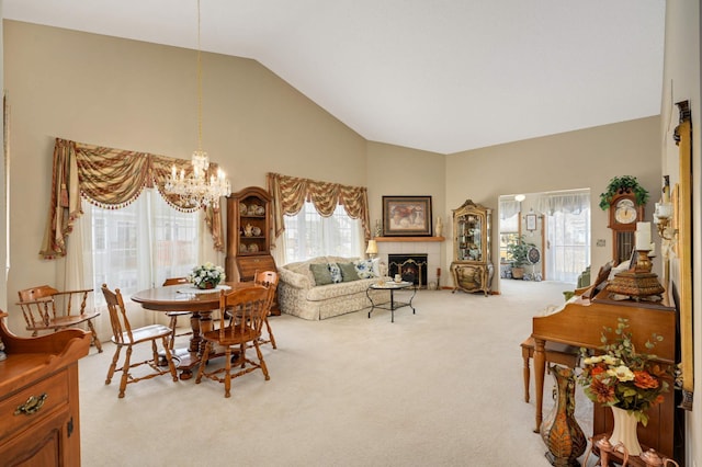 dining area with an inviting chandelier, a fireplace, carpet floors, and high vaulted ceiling