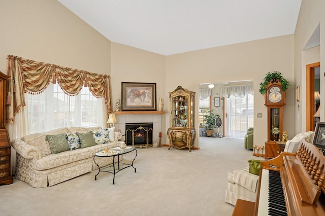 living area featuring carpet, high vaulted ceiling, and a tile fireplace