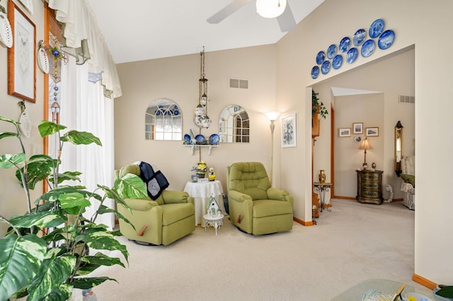 carpeted living room with visible vents, baseboards, and a ceiling fan