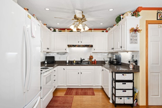 kitchen featuring light wood finished floors, white appliances, white cabinetry, and a sink