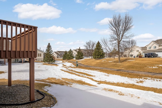 yard layered in snow with a residential view