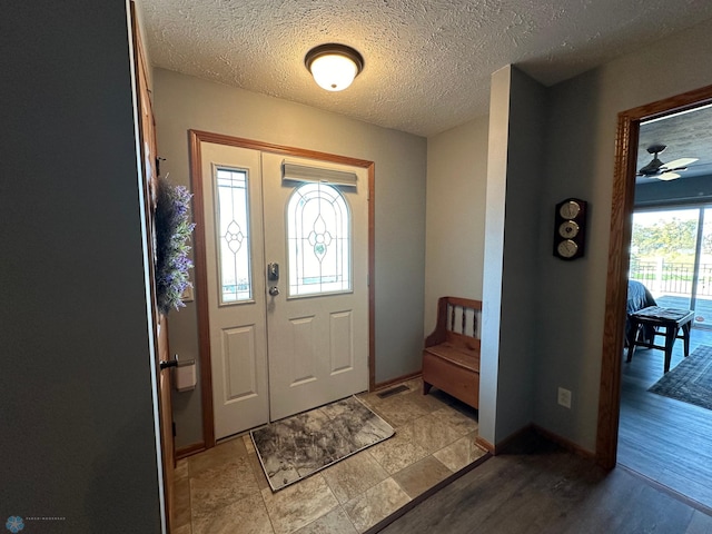 foyer featuring a textured ceiling and baseboards