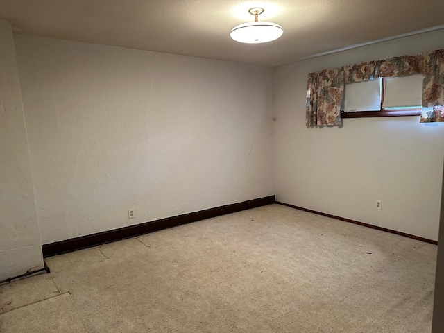 unfurnished room featuring light colored carpet and baseboards