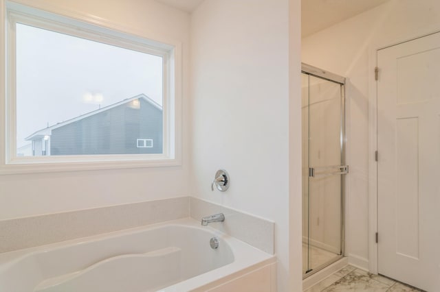 full bath with marble finish floor, a shower stall, and a garden tub