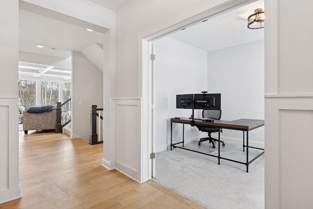 office space with light wood-style flooring, coffered ceiling, and baseboards