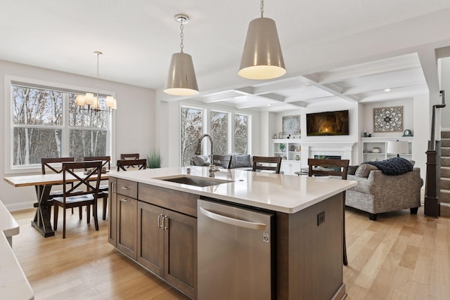 kitchen with dishwasher, light wood-type flooring, a fireplace, coffered ceiling, and a sink