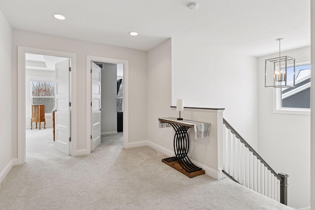 hallway featuring baseboards, recessed lighting, carpet flooring, an upstairs landing, and a chandelier