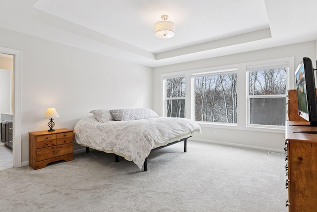 bedroom featuring carpet flooring, multiple windows, a raised ceiling, and baseboards