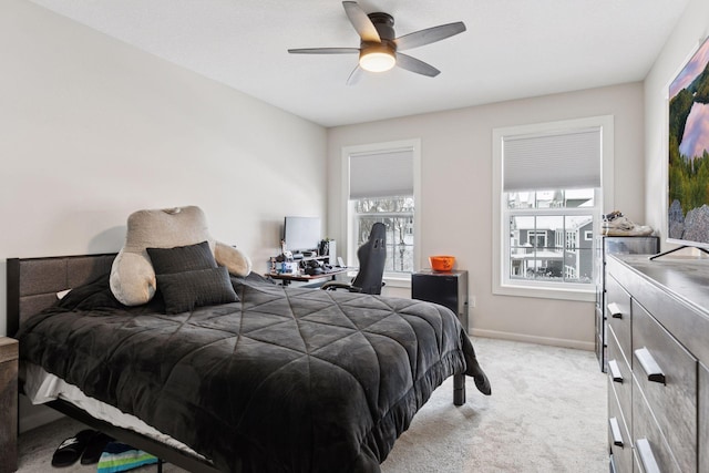 bedroom featuring ceiling fan, baseboards, and light carpet