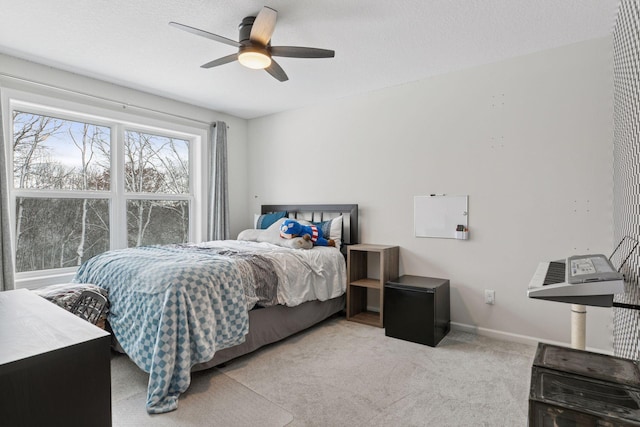 bedroom featuring baseboards, carpet floors, a textured ceiling, and a ceiling fan