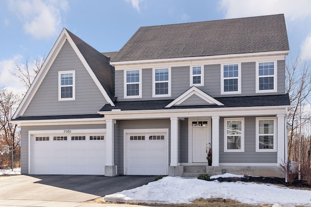 view of front of house featuring aphalt driveway, an attached garage, and a shingled roof