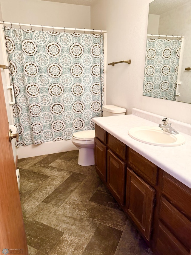 bathroom with shower / bath combination with curtain, vanity, and toilet