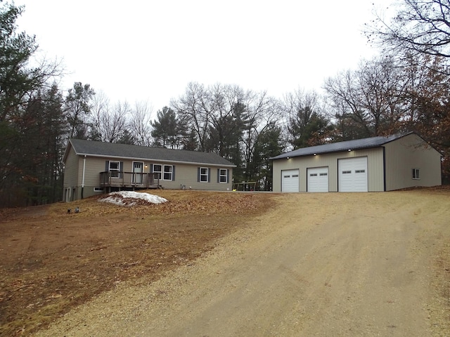 view of front of home with a garage and an outbuilding