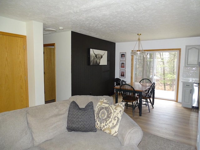 dining room with light wood-type flooring and a textured ceiling