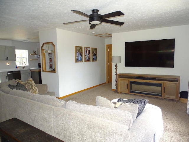 living area featuring a textured ceiling, light carpet, a ceiling fan, and baseboards