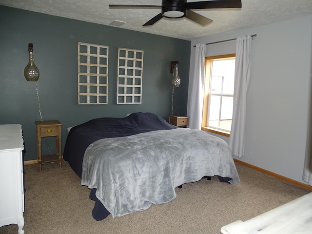 bedroom featuring carpet floors, visible vents, baseboards, and a textured ceiling