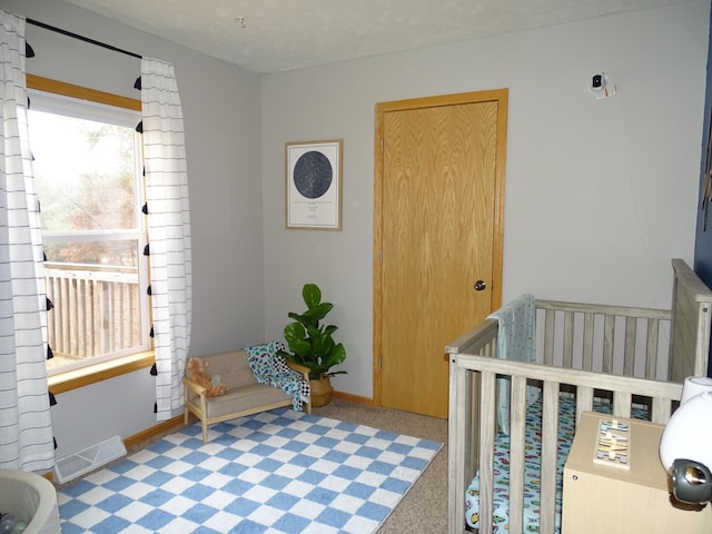 bedroom with a textured ceiling, visible vents, and baseboards