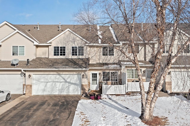 multi unit property featuring driveway, a garage, a shingled roof, a porch, and brick siding