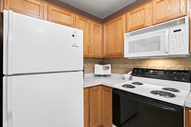 kitchen featuring white appliances, light countertops, a textured ceiling, and decorative backsplash