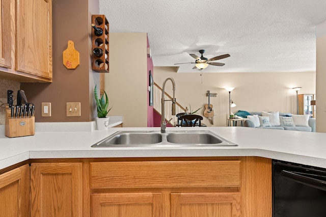 kitchen featuring dishwasher, open floor plan, light countertops, a textured ceiling, and a sink