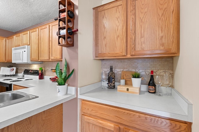 kitchen featuring electric stove, light countertops, light brown cabinets, and white microwave