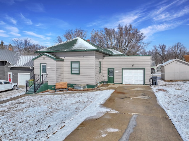 view of front of property featuring a garage, driveway, fence, and an outdoor structure