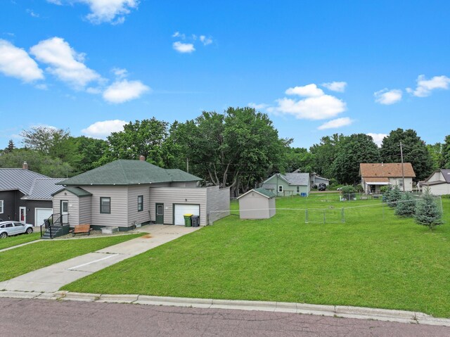 312 4th St E, Jasper, MN 56144 - view of front facade with a garage, concrete driveway, an outdoor structure, and view of scattered trees