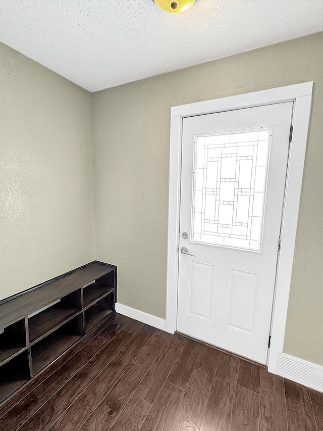 312 4th St E, Jasper, MN 56144 - entrance foyer with dark wood-style flooring, baseboards, and a textured ceiling