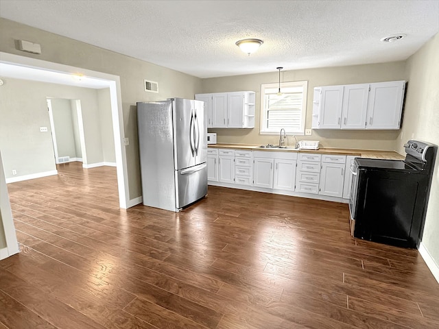 312 4th St E, Jasper, MN 56144 - kitchen with freestanding refrigerator, black / electric stove, a textured ceiling, dark wood-type flooring, and open shelves