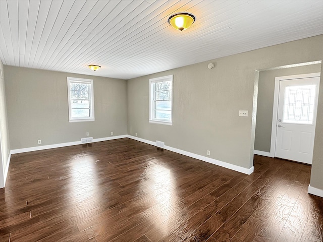 312 4th St E, Jasper, MN 56144 - unfurnished room featuring plenty of natural light, dark wood-type flooring, and baseboards