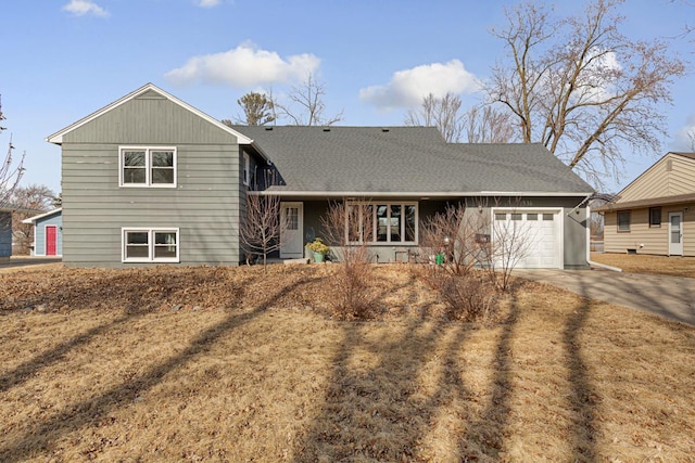 split level home with driveway, roof with shingles, and an attached garage