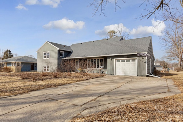 view of front of house featuring a shingled roof, driveway, and an attached garage