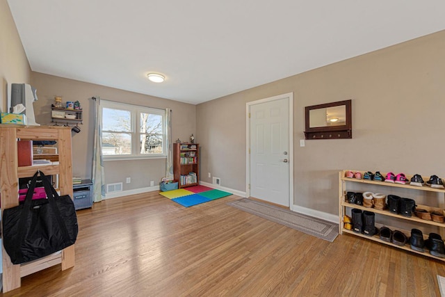 playroom with visible vents, baseboards, and wood finished floors