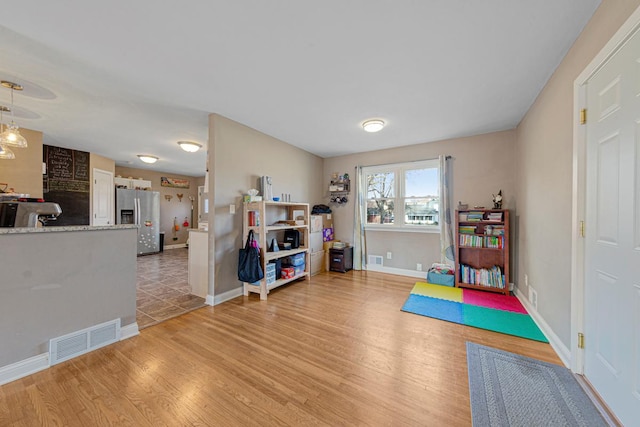 game room with light wood finished floors, baseboards, and visible vents