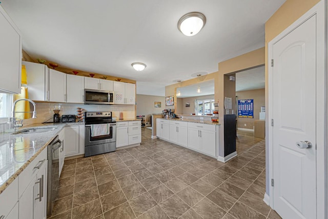 kitchen featuring a wealth of natural light, tasteful backsplash, appliances with stainless steel finishes, and a sink