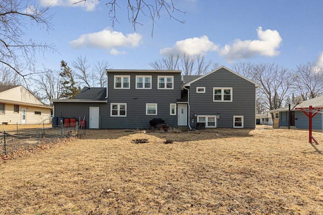 rear view of property featuring fence