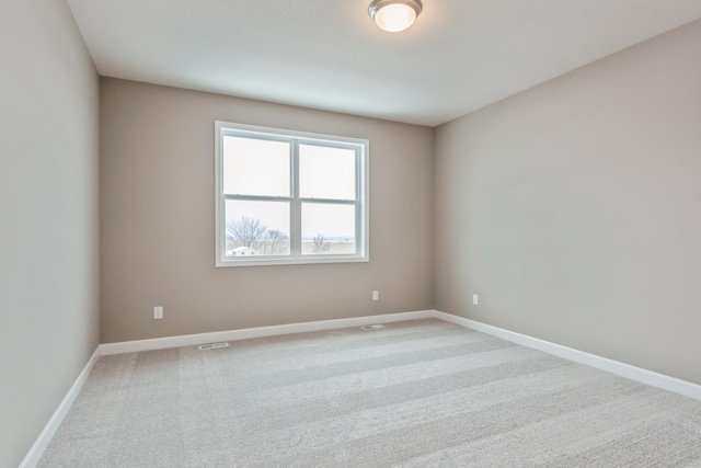 carpeted empty room featuring baseboards