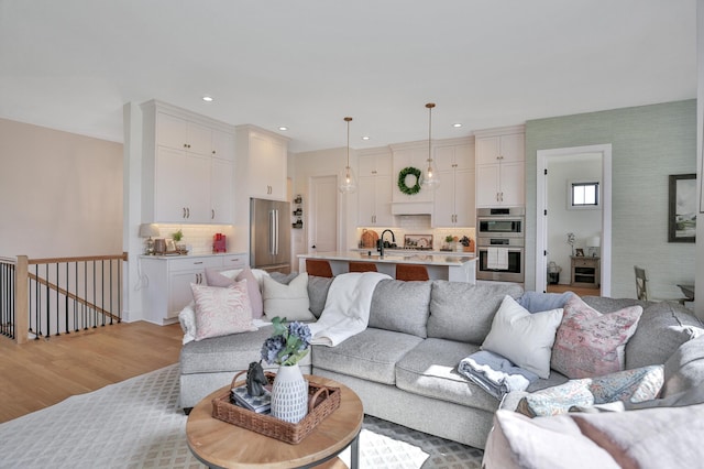 living room with light wood finished floors and recessed lighting